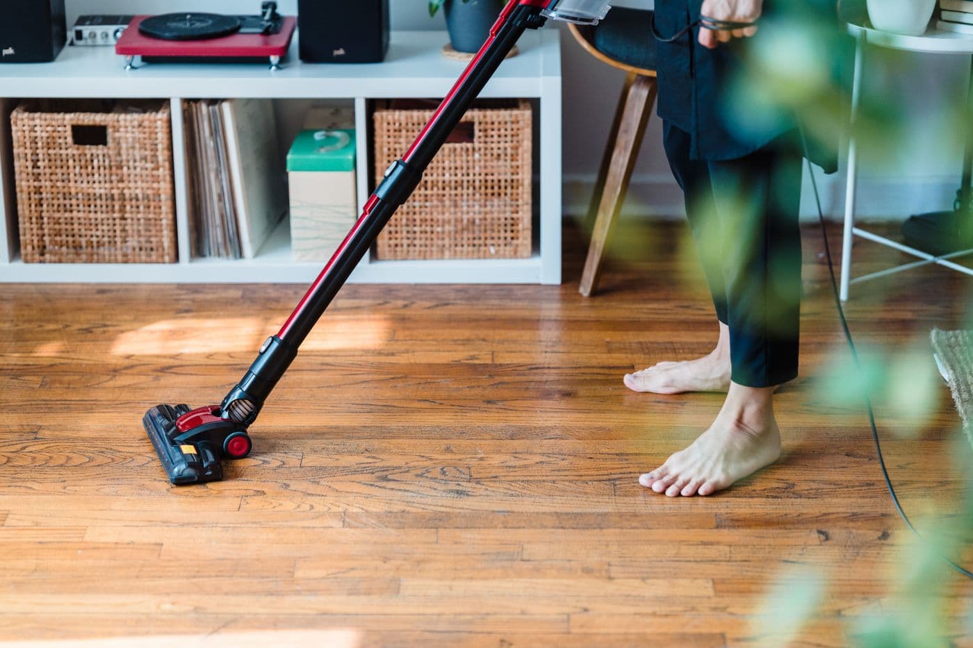Aspirateur sans fil nettoyant un plancher de bois franc dans une maison
