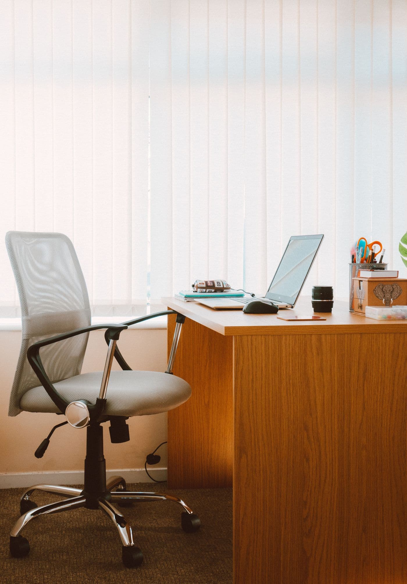Espace de travail propre avec bureau et chaise près d’une fenêtre lumineuse