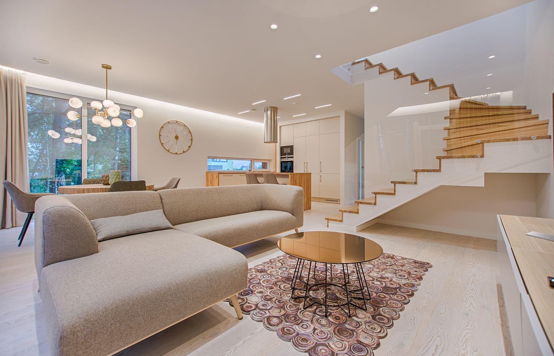 Salon lumineux fraîchement nettoyé avec escalier et grandes fenêtres